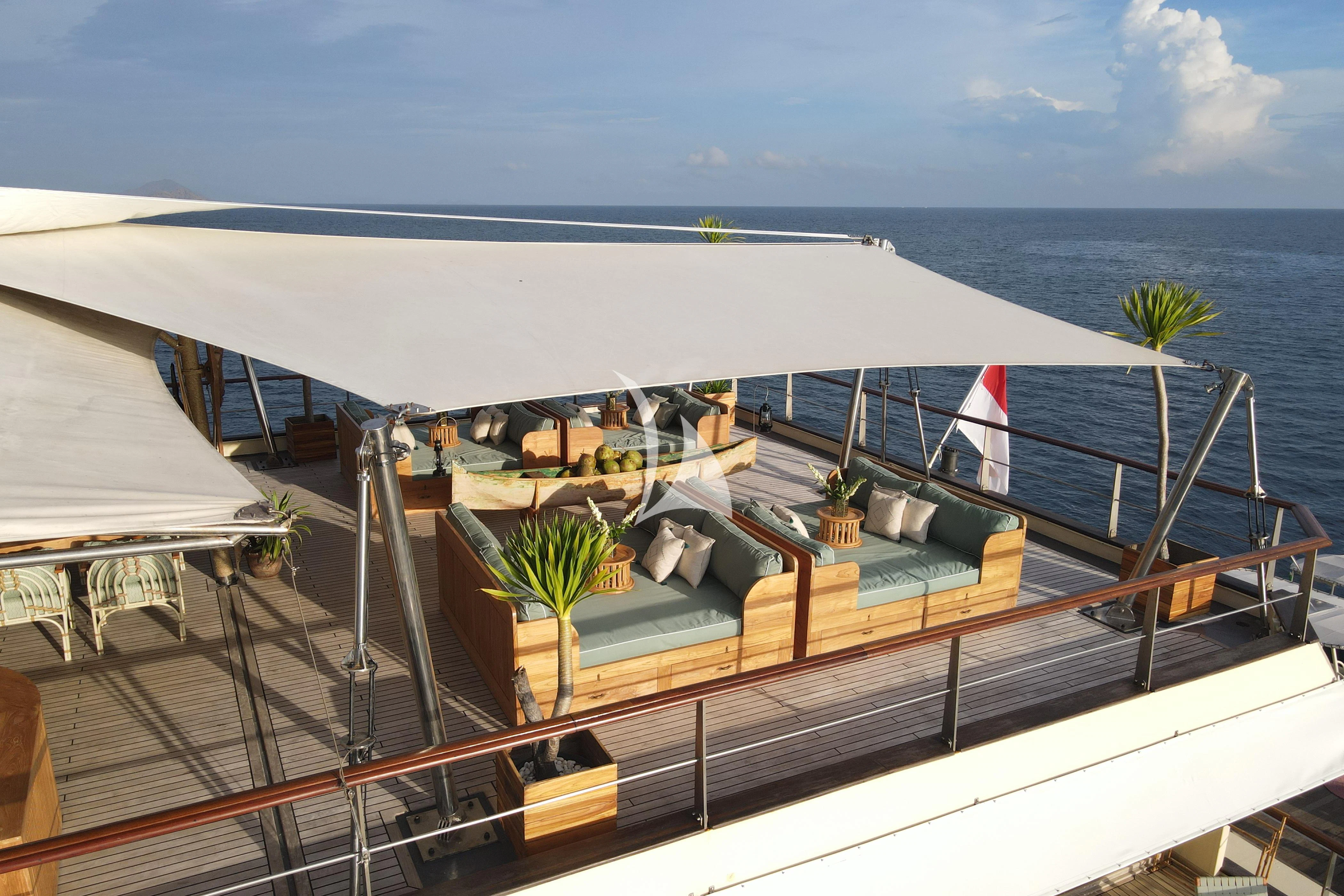 a deck with a large white tent and a tree on it aboard KUDANIL EXPLORER Yacht for Sale
