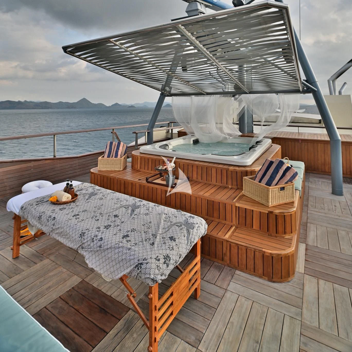 a table with chairs on it next to a large body of water aboard KUDANIL EXPLORER Yacht for Sale