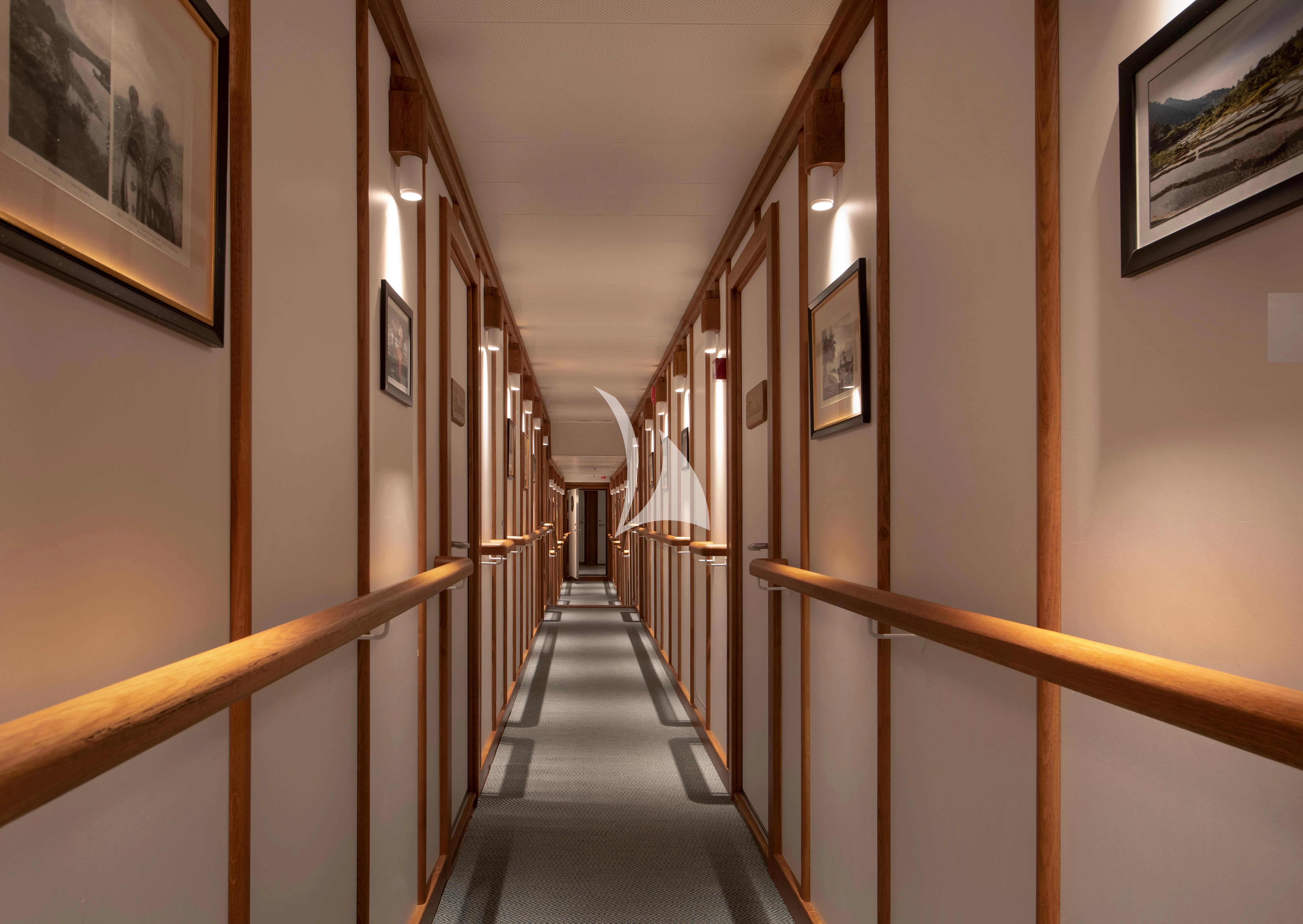 a long hallway with a railing aboard KUDANIL EXPLORER Yacht for Sale