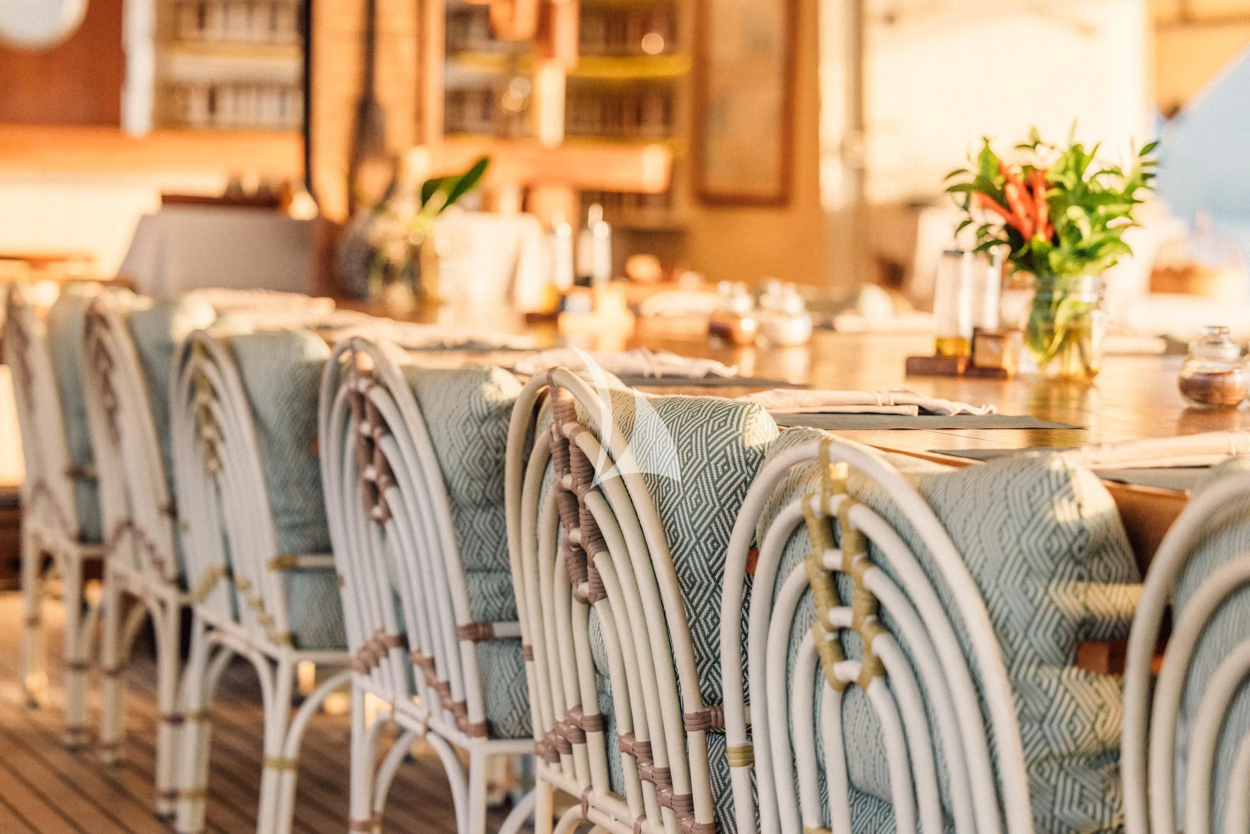 a table with chairs and a vase of flowers on it aboard KUDANIL EXPLORER Yacht for Sale