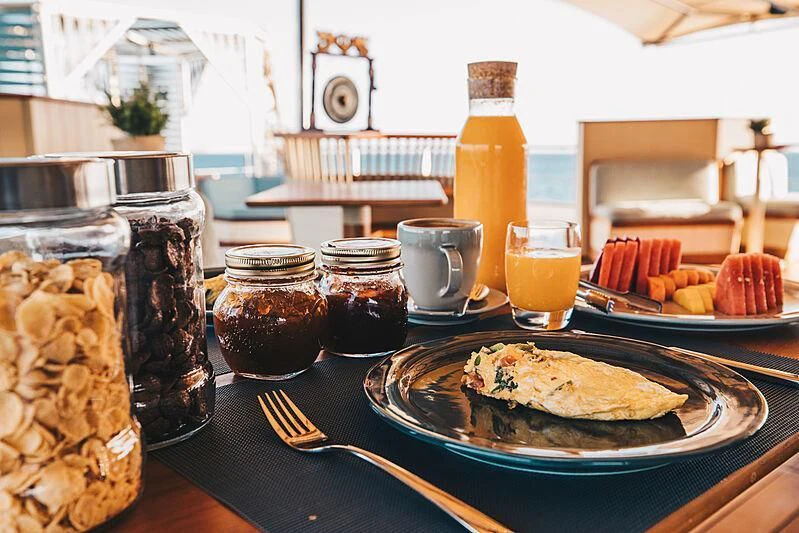 a table with plates of food and glasses on it aboard KUDANIL EXPLORER Yacht for Sale