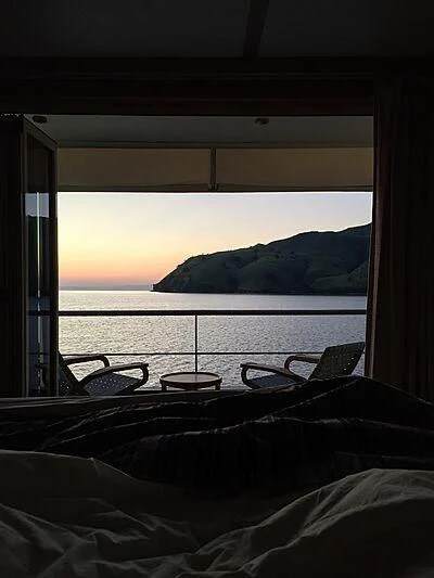a bed with a view of the ocean and a mountain aboard KUDANIL EXPLORER Yacht for Sale