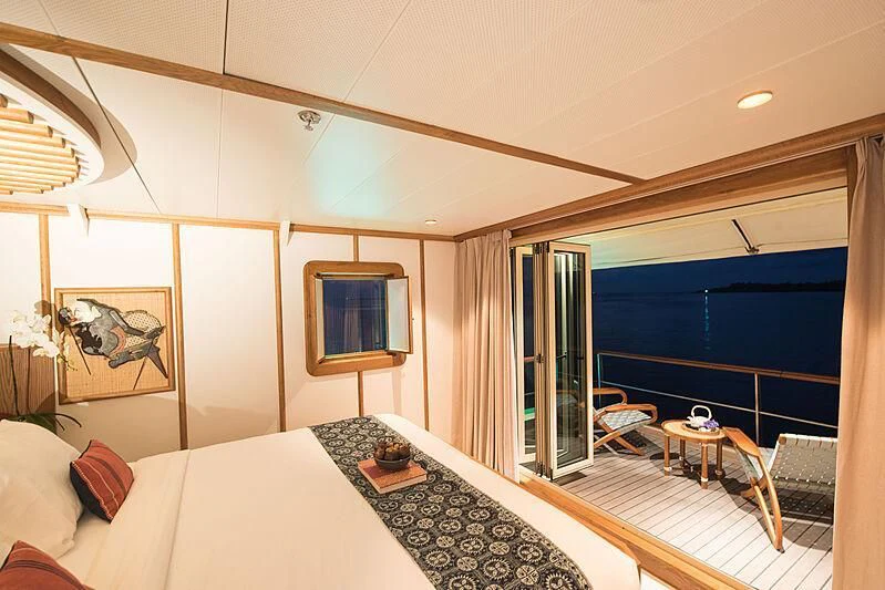 a room with a bed and a table aboard KUDANIL EXPLORER Yacht for Sale