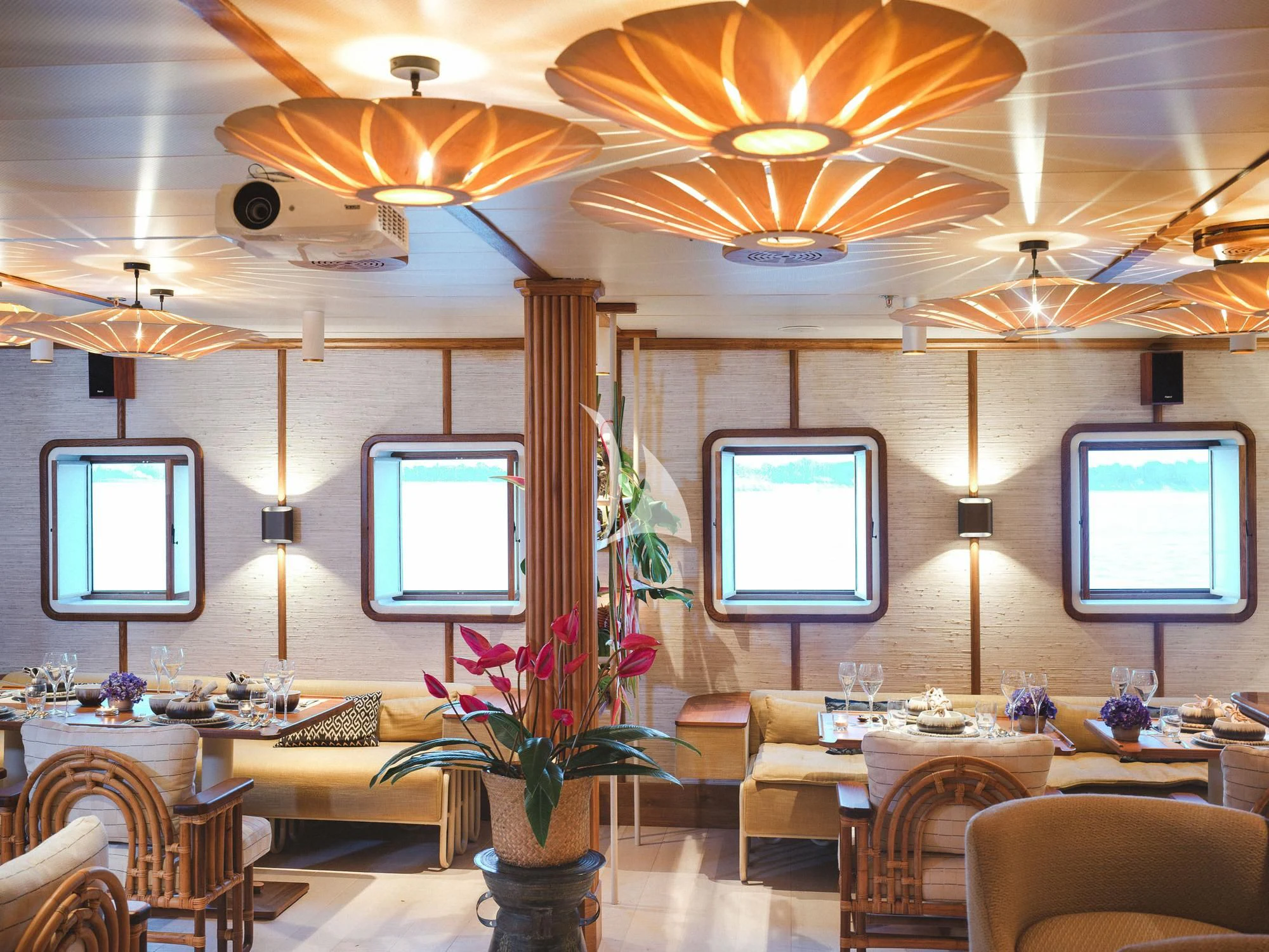 a room with a large window and a table with chairs and a television aboard KUDANIL EXPLORER Yacht for Sale