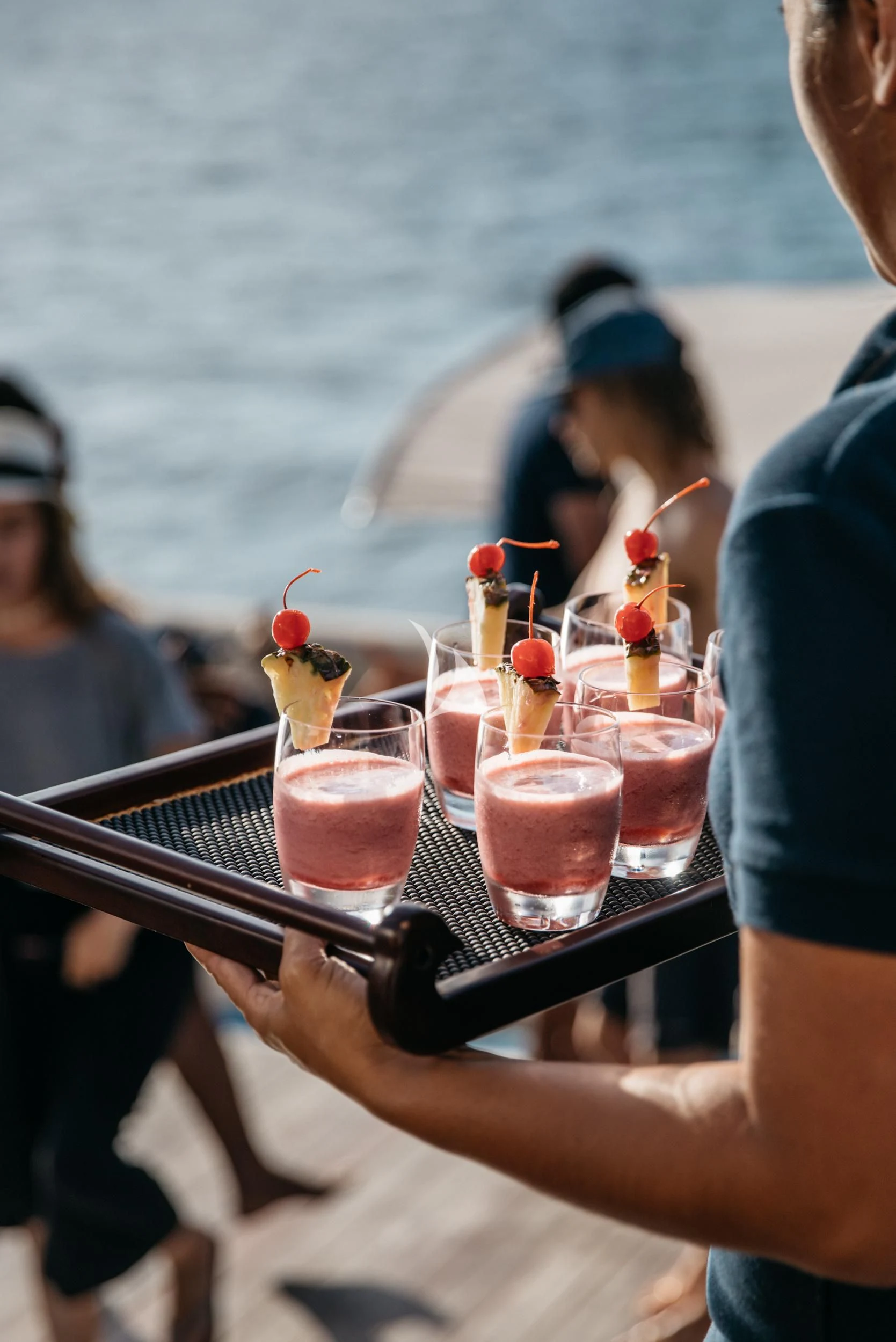 a person holding a tablet and a drink on a boat aboard KUDANIL EXPLORER Yacht for Sale