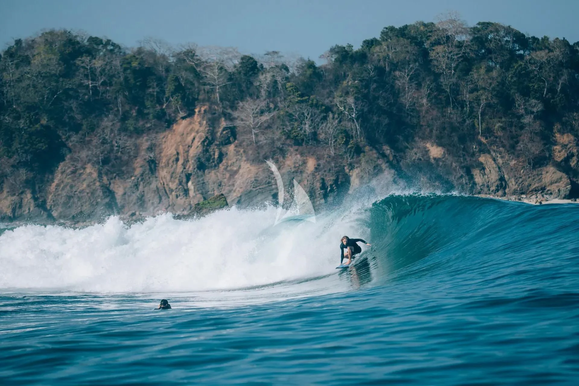 a couple of people surfing in the sea aboard KUDANIL EXPLORER Yacht for Sale