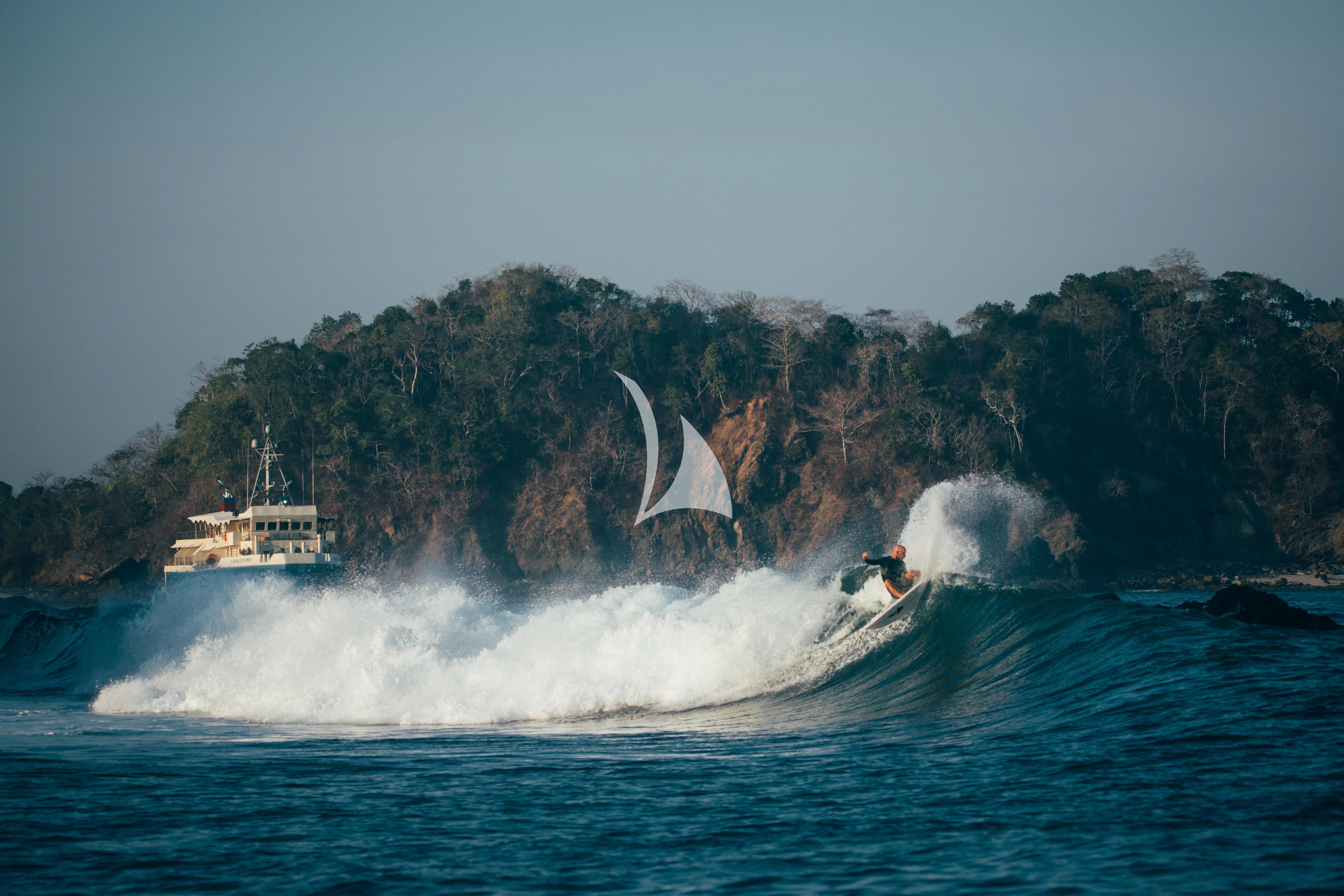 a person surfing on the waves aboard KUDANIL EXPLORER Yacht for Sale