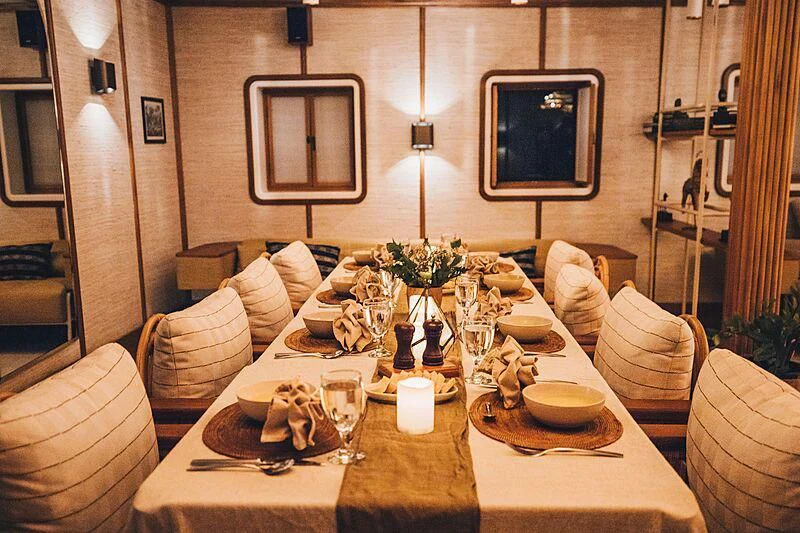 a table set with plates and chairs aboard KUDANIL EXPLORER Yacht for Sale