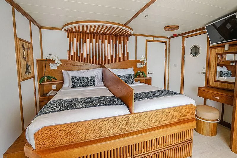 a bedroom with a bed and a table aboard KUDANIL EXPLORER Yacht for Sale