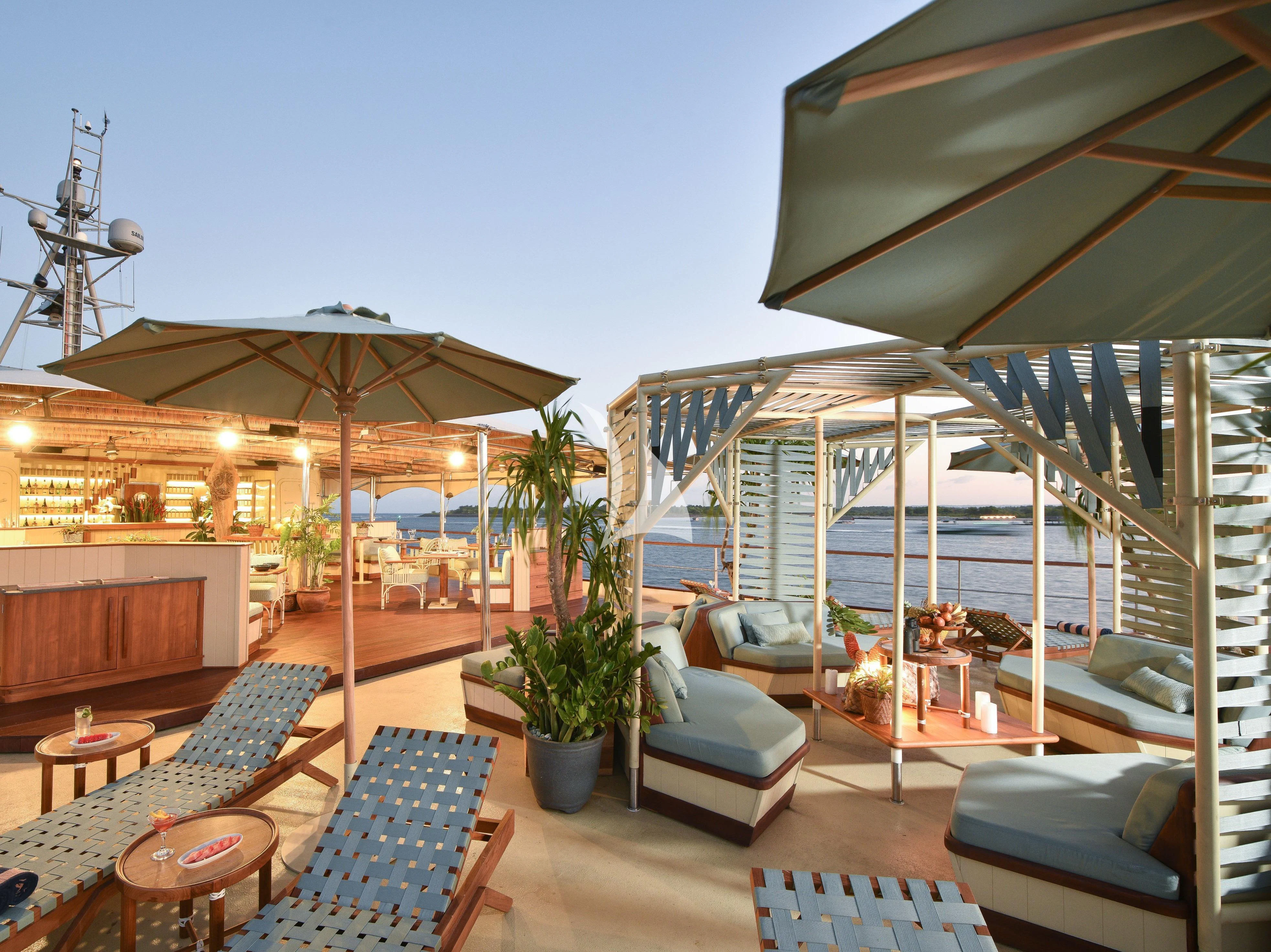 a patio with a lounge chair and a pool aboard KUDANIL EXPLORER Yacht for Sale