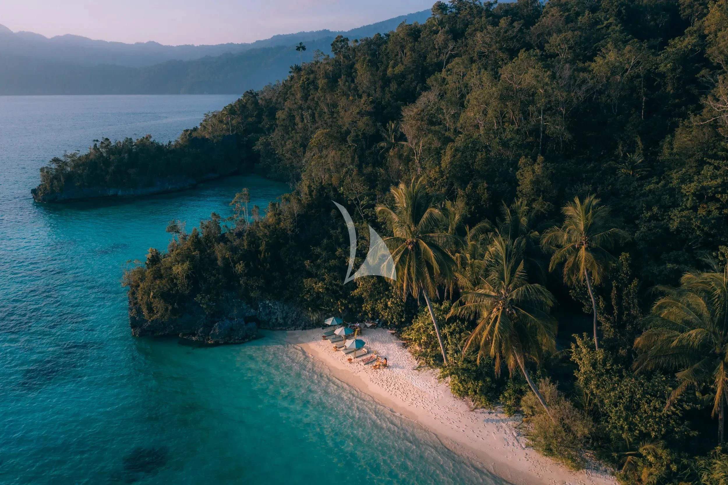 a beach with trees and a body of water aboard KUDANIL EXPLORER Yacht for Sale