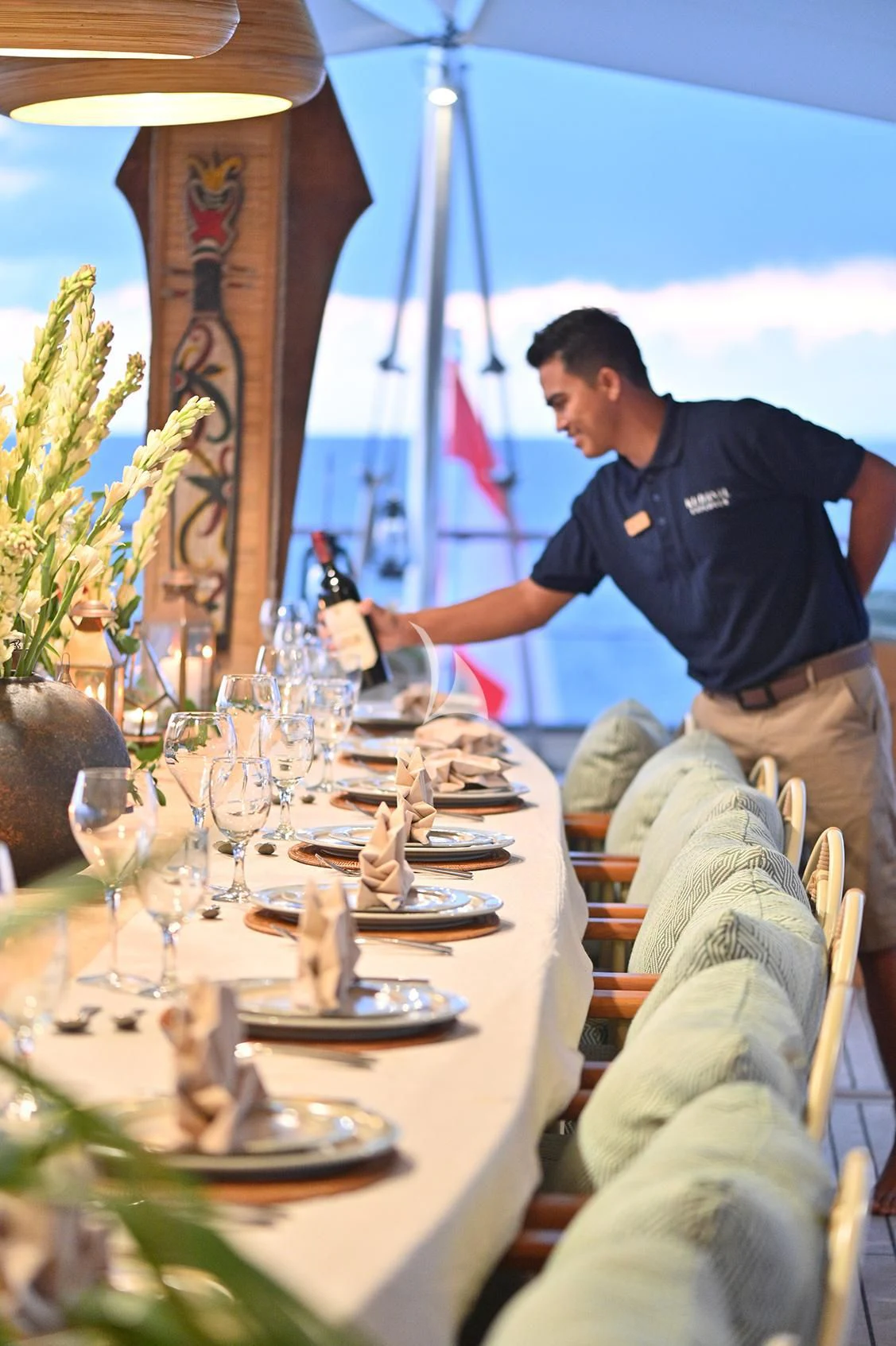 a person pouring wine into glasses aboard KUDANIL EXPLORER Yacht for Sale