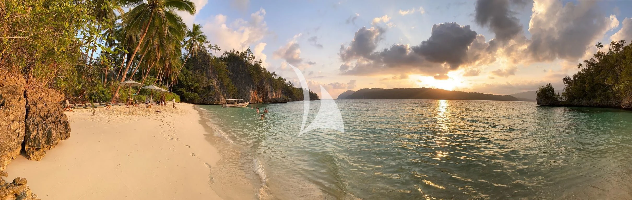 a beach with a body of water and trees on the side aboard KUDANIL EXPLORER Yacht for Sale