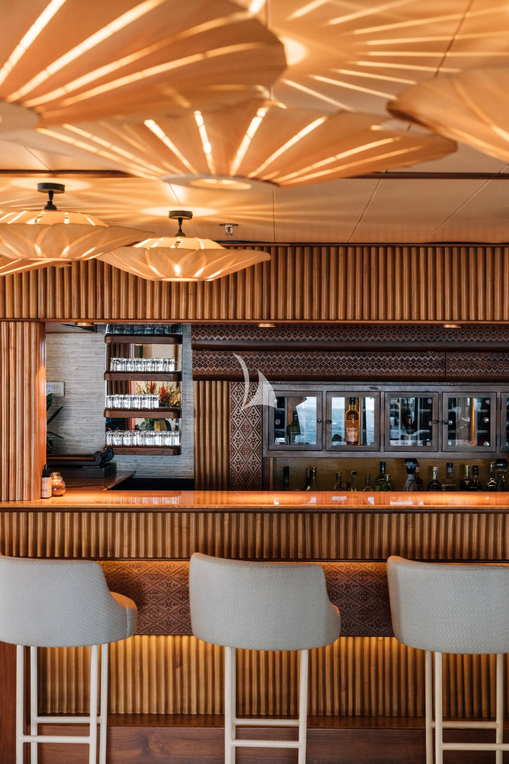 a kitchen with a bar and chairs aboard KUDANIL EXPLORER Yacht for Sale