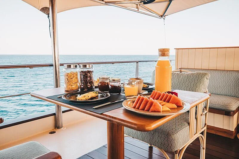 a table with food on it aboard KUDANIL EXPLORER Yacht for Sale
