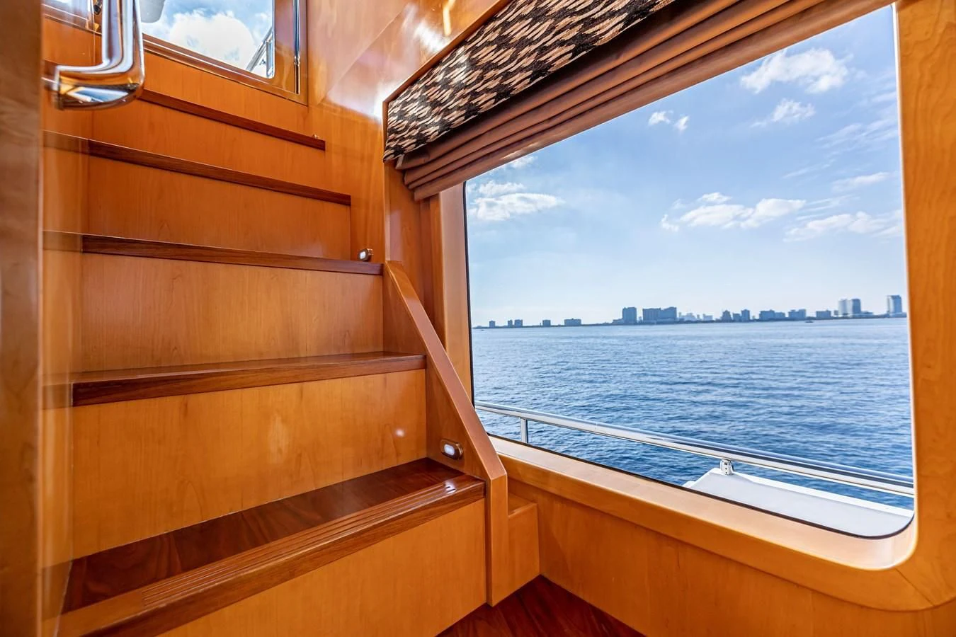 a window with a view of a city and water below aboard SALVATORE II Yacht for Sale
