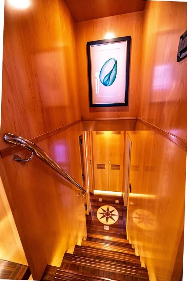 a wooden staircase with a painting on the wall aboard SALVATORE II Yacht for Sale