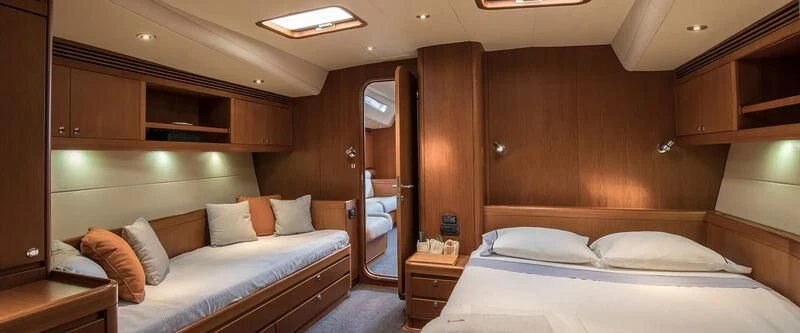 a room with a bed and a dresser aboard ARIA Yacht for Charter