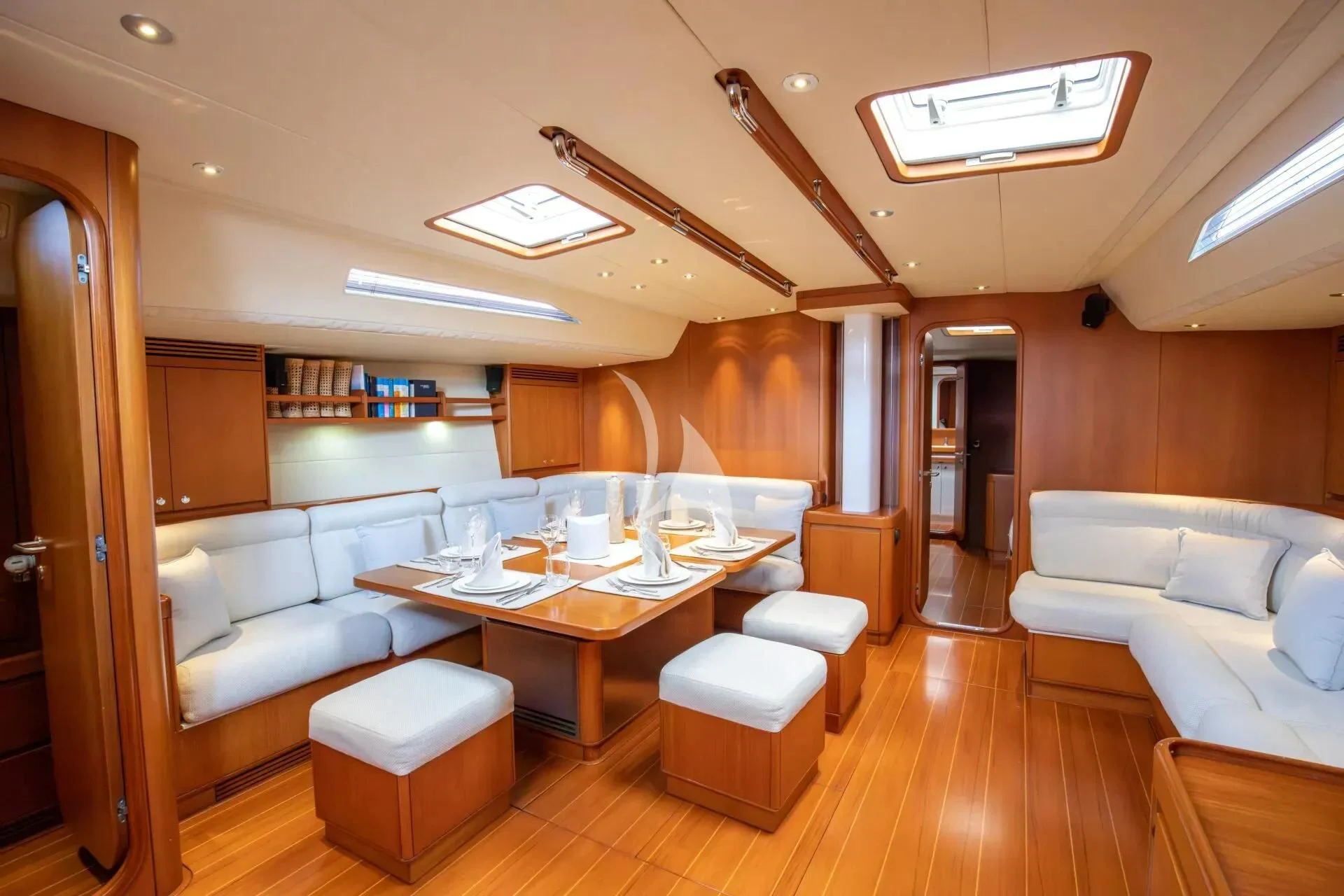 a room with a table chairs and a couch aboard ARIA Yacht for Charter