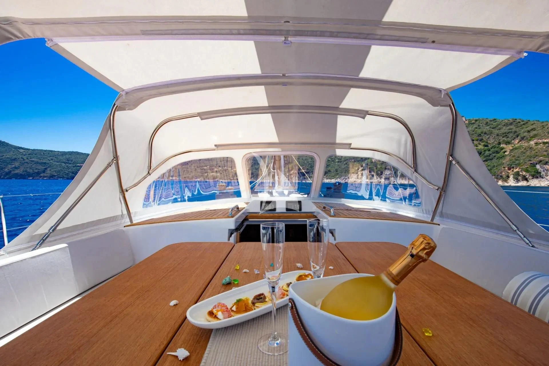 a table with food and drinks on it by a boat aboard ARIA Yacht for Charter