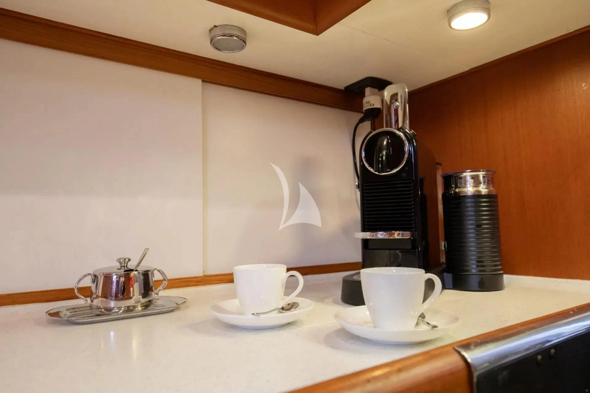a coffee maker and cups on a counter aboard ARIA Yacht for Charter
