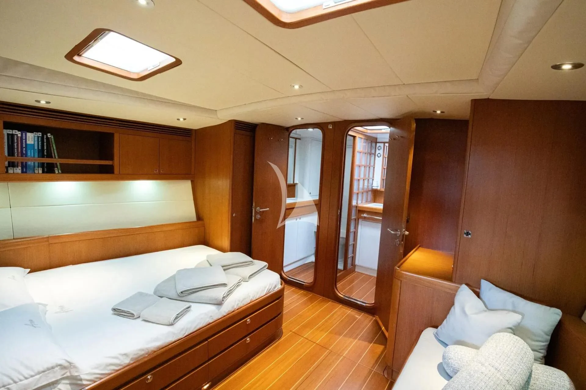 a room with a bed and a chair aboard ARIA Yacht for Charter
