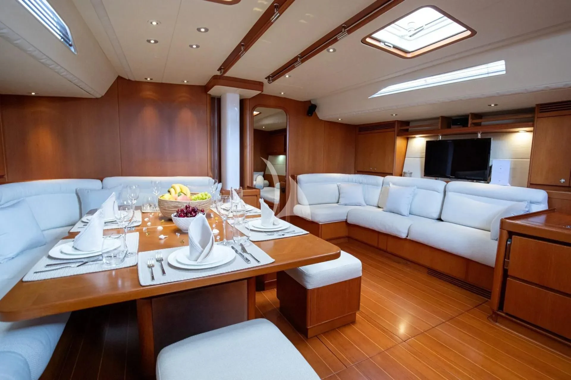 a large room with a table and chairs aboard ARIA Yacht for Charter