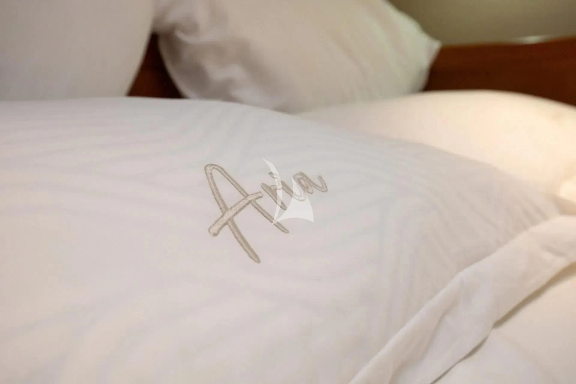 a bed with a white comforter and a drawing on it aboard ARIA Yacht for Charter