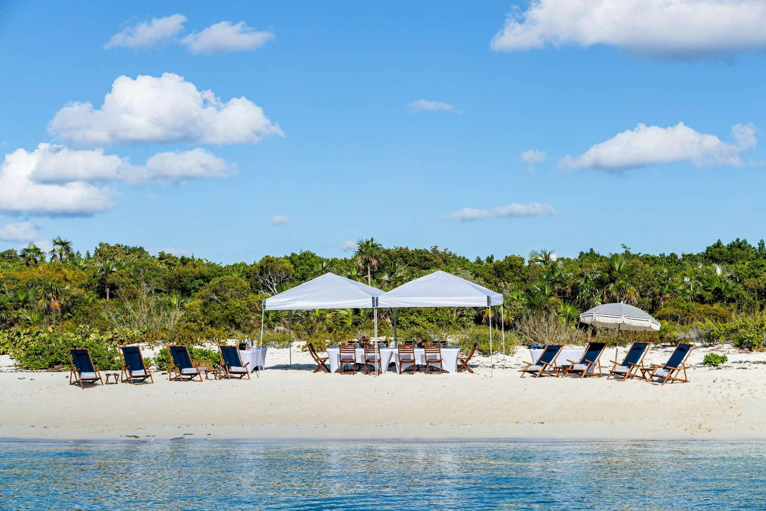 a beach with lounge chairs and umbrellas aboard NEENAH Yacht for Charter