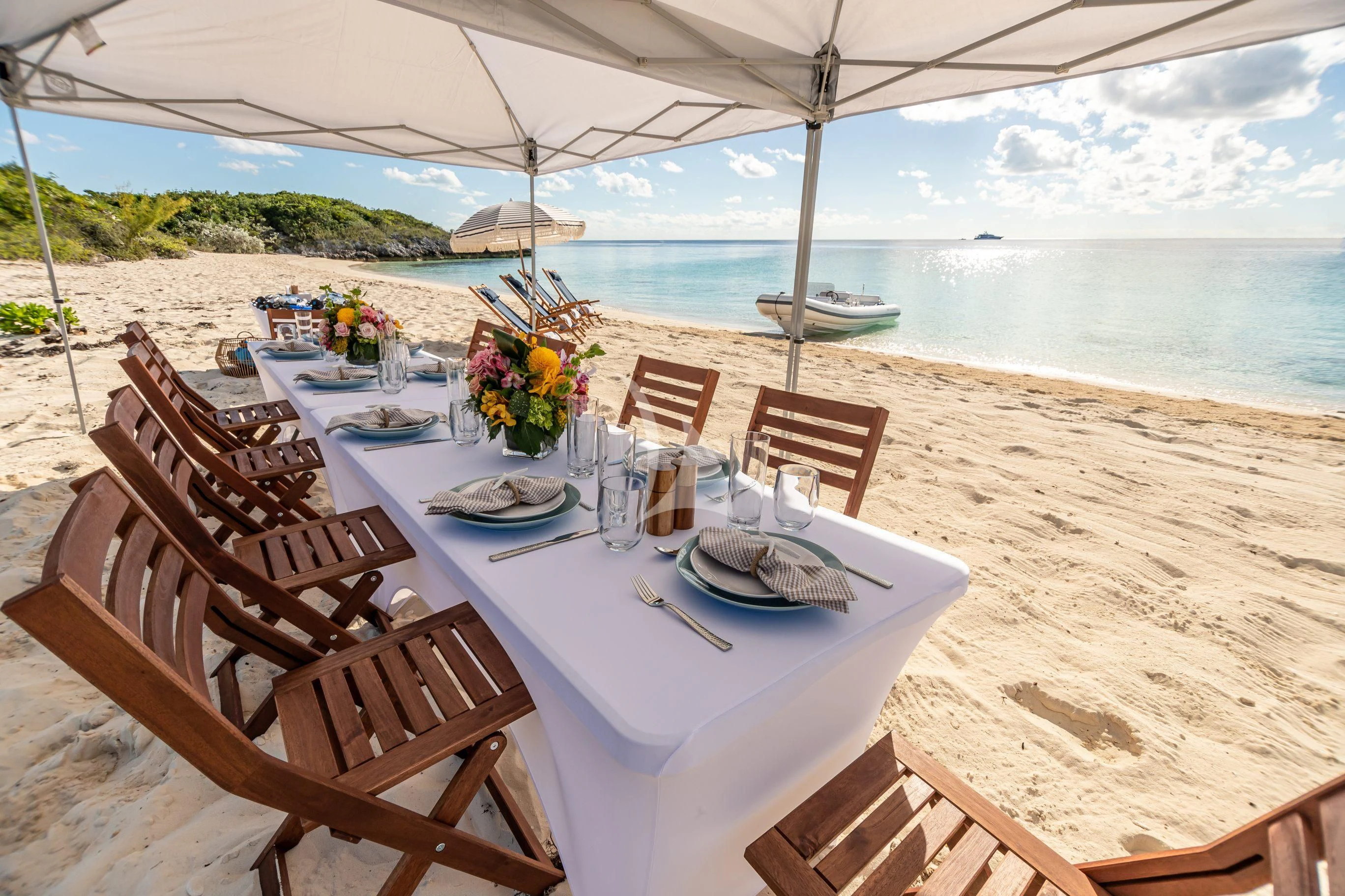 a table set for a meal on a beach aboard NEENAH Yacht for Charter