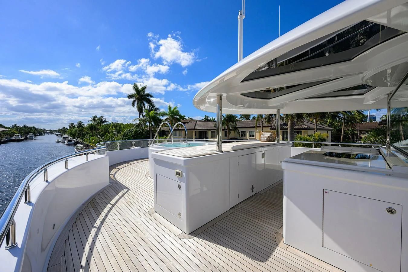 a deck with a large pool and a deck with trees and blue sky aboard NEENAH Yacht for Charter