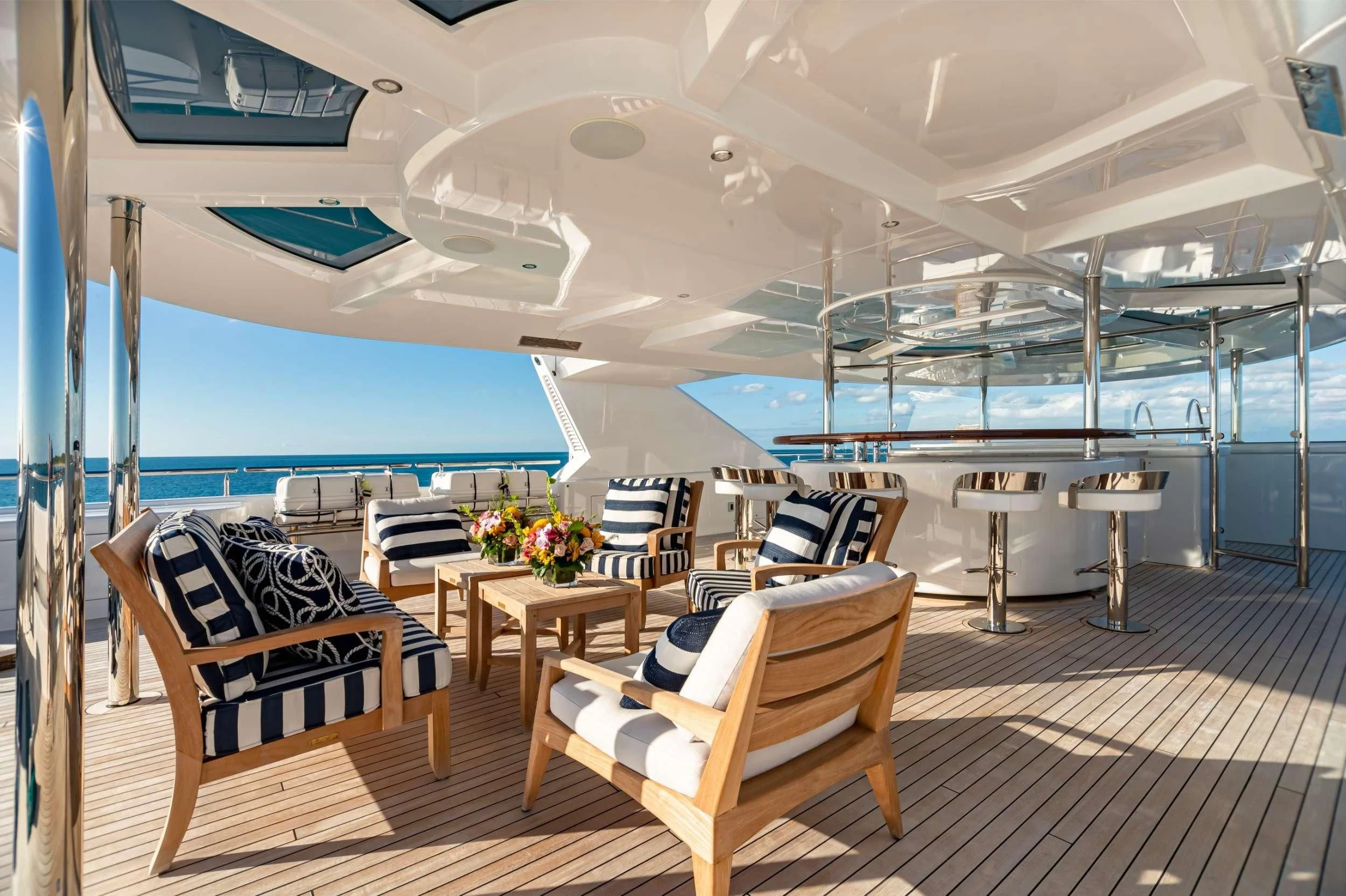 a room with a table chairs and a pool aboard NEENAH Yacht for Charter