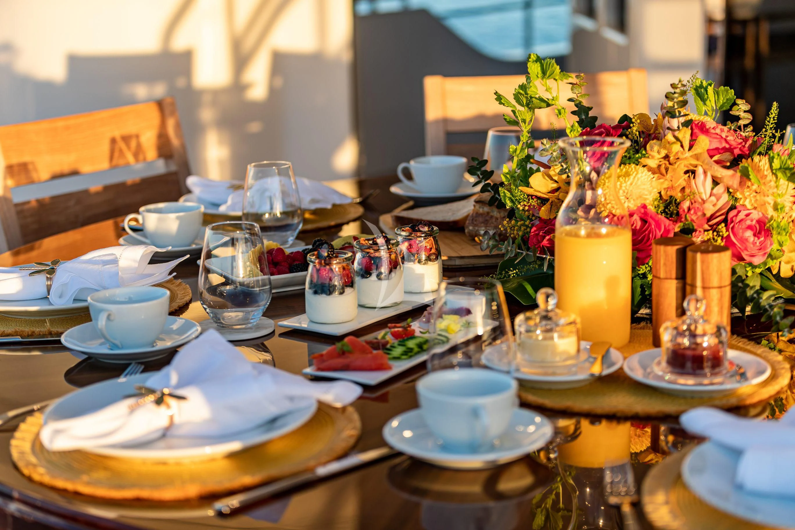a table with plates and glasses aboard NEENAH Yacht for Charter