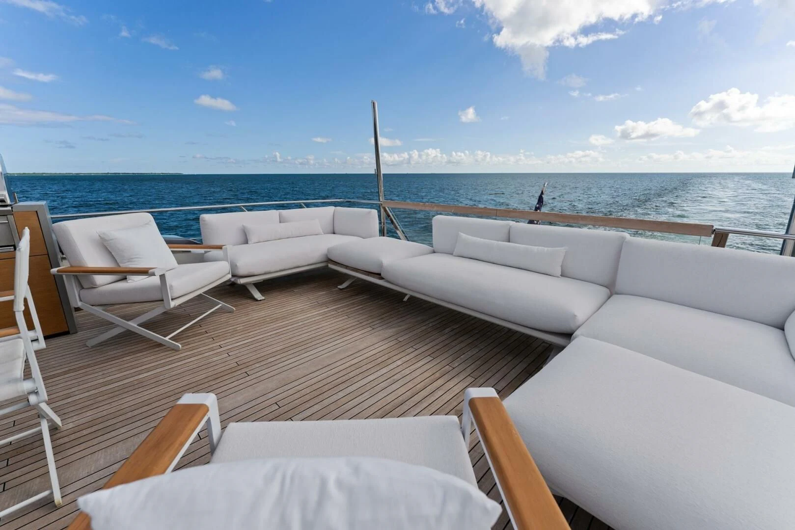 a deck with chairs and a body of water in the background aboard GATSBY Yacht for Charter