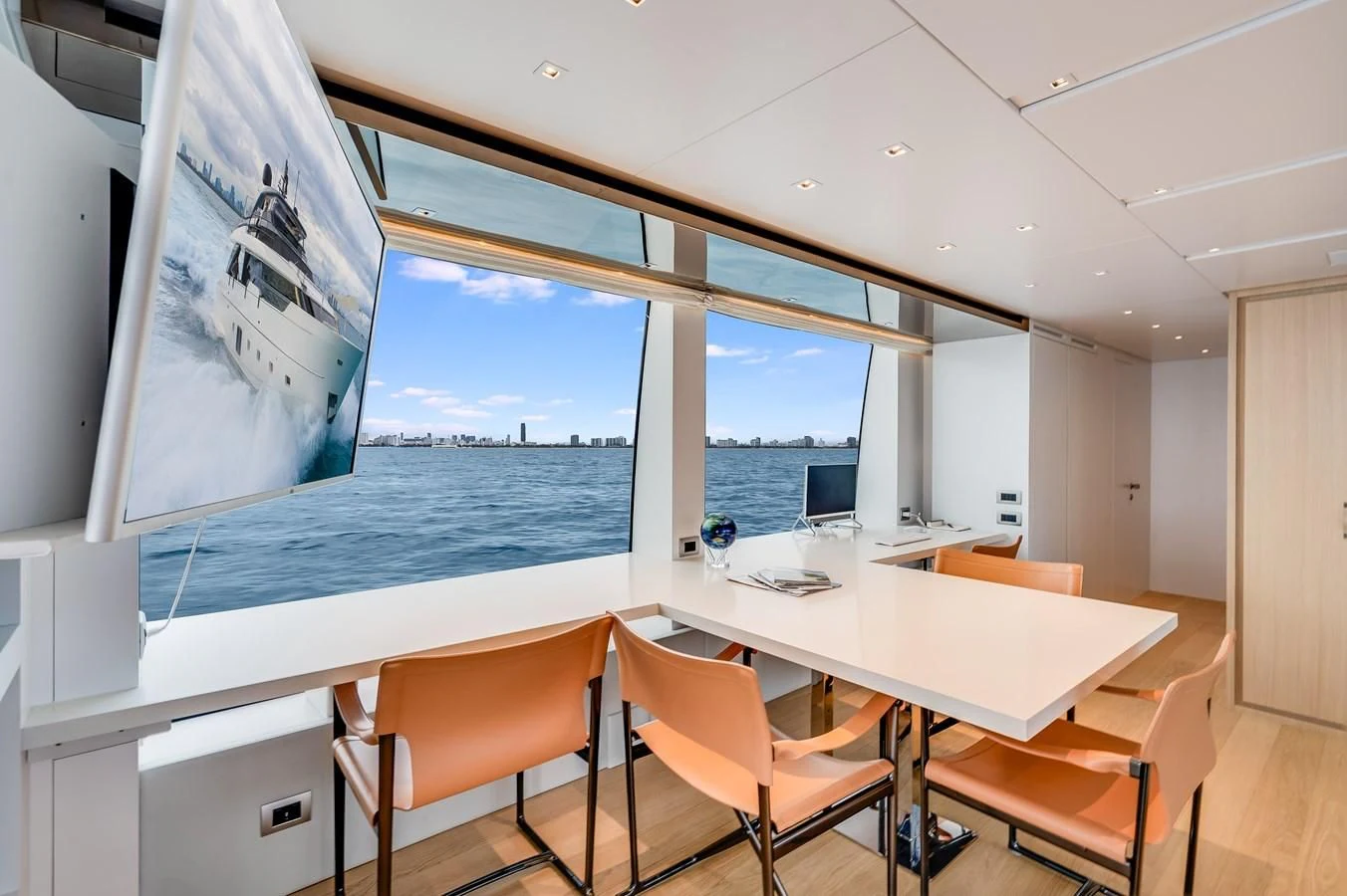 a room with a table and chairs and a large window aboard GATSBY Yacht for Charter