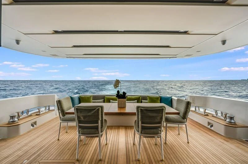 a large white room with a table and chairs and a view of the ocean aboard GATSBY Yacht for Charter