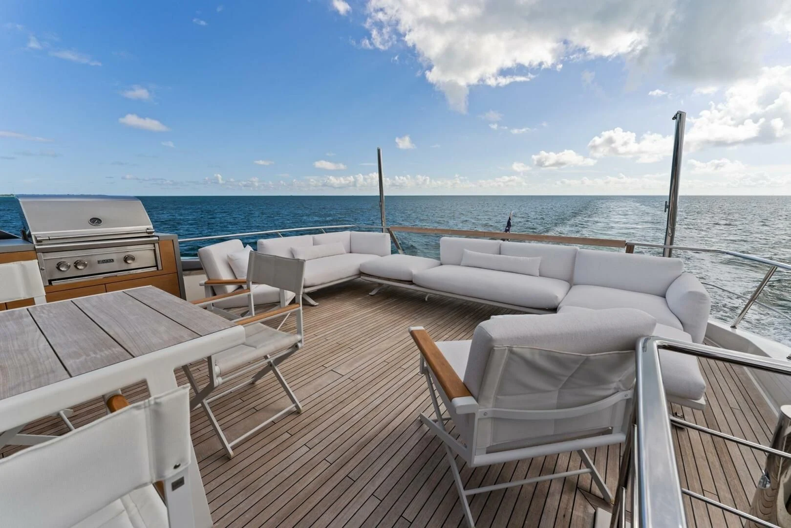 a deck with chairs and a body of water in the background aboard GATSBY Yacht for Charter
