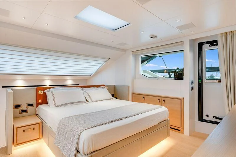 a bedroom with a bed and a window aboard GATSBY Yacht for Charter