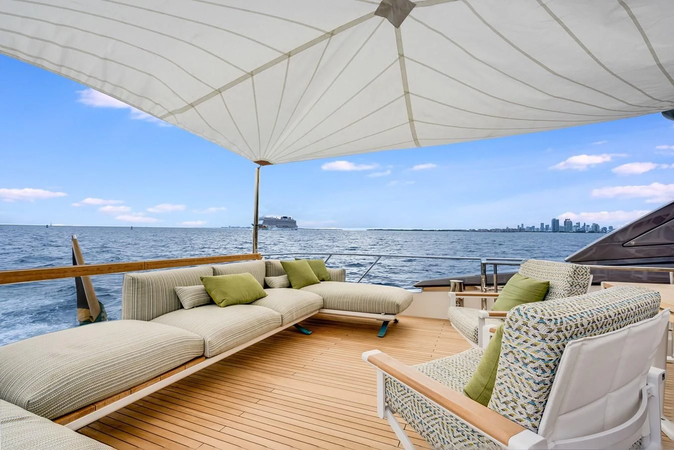 a deck with chairs and a large body of water in the background aboard GATSBY Yacht for Charter