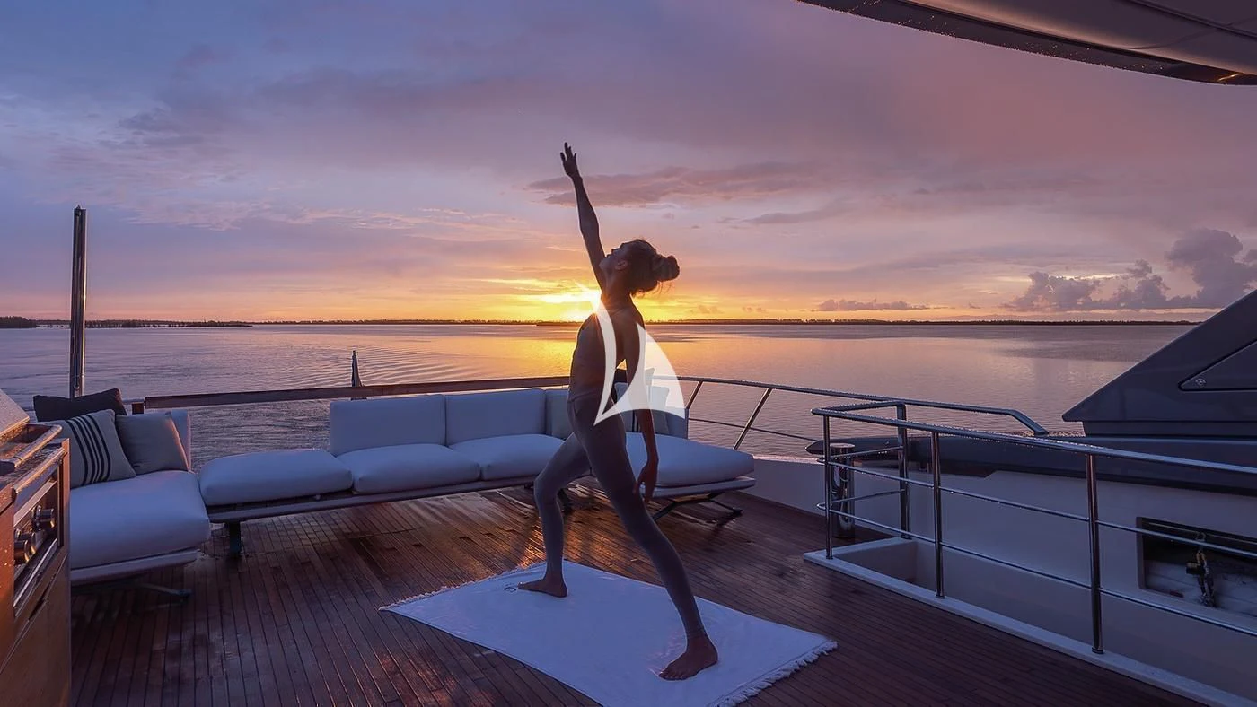 a person sitting on a deck with the arms up aboard GATSBY Yacht for Charter