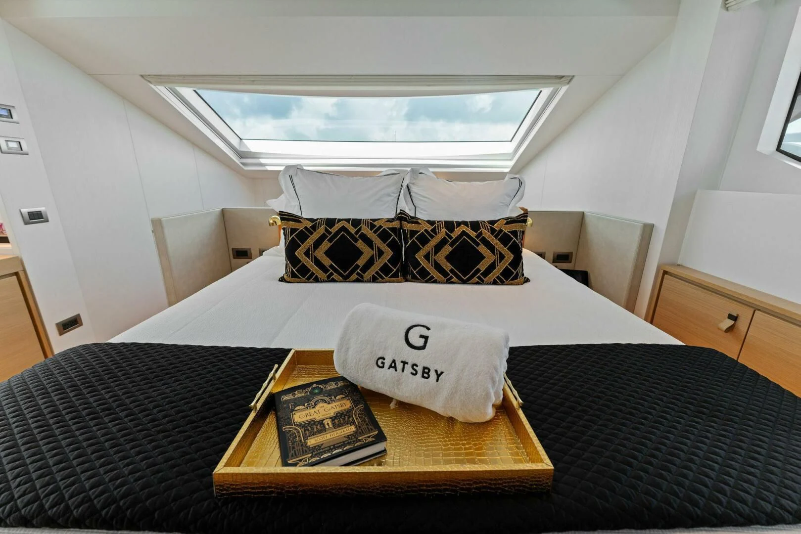 a bed with a pillow and a book on it aboard GATSBY Yacht for Charter