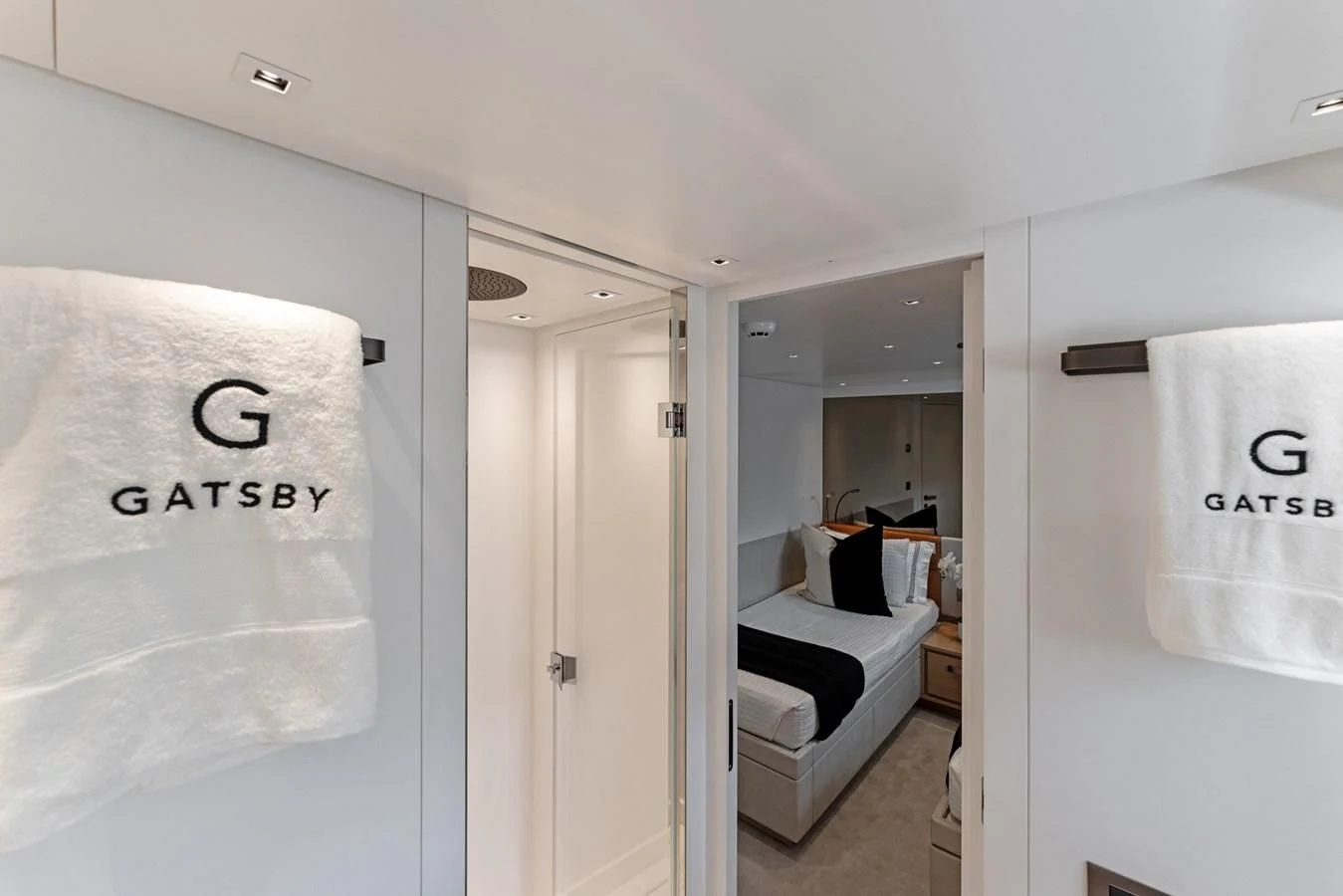 a white bathroom with a white shower curtain and a white bed aboard GATSBY Yacht for Charter