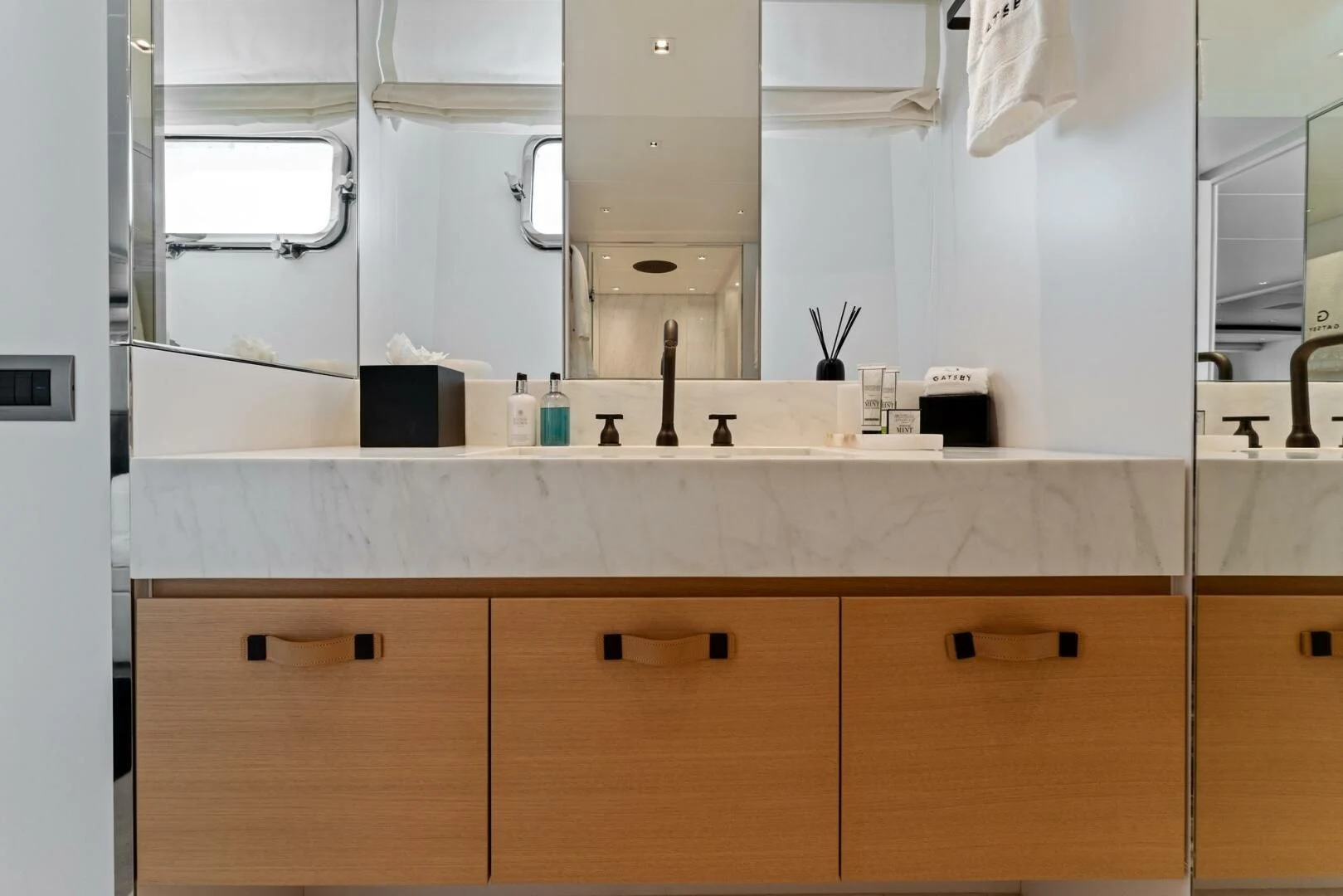 a bathroom with a mirror and cabinets aboard GATSBY Yacht for Charter