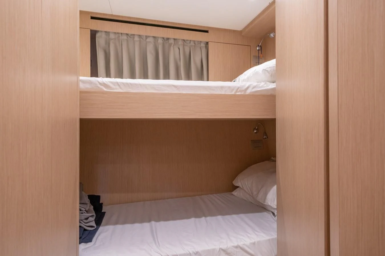 a bed with a white sheet aboard GATSBY Yacht for Charter