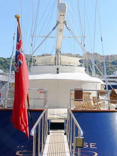 a boat with a flag on it aboard IS A ROSE Yacht for Sale