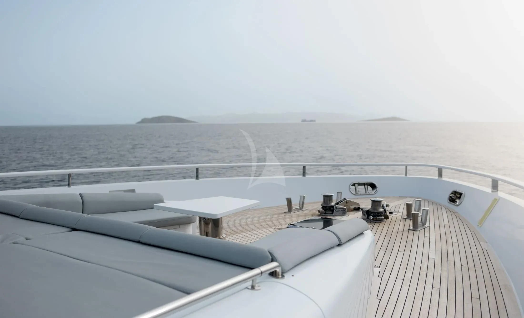 a deck with a view of the ocean and a large ship aboard MAC Yacht for Sale