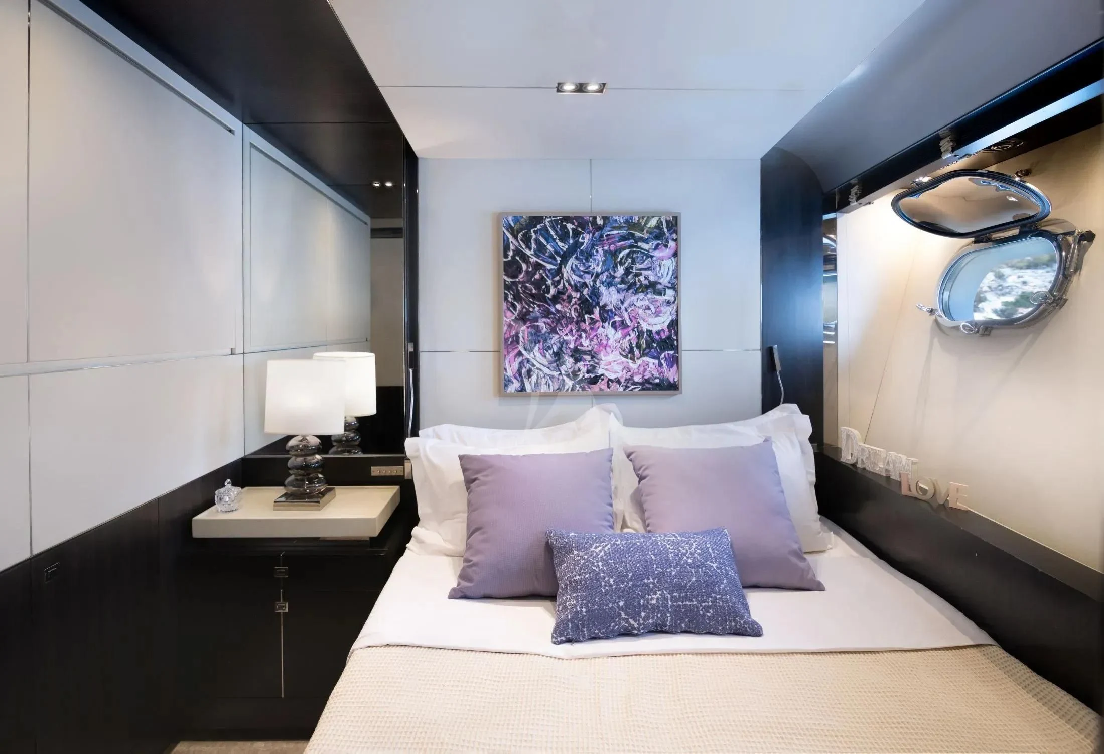 a bed with pillows and a painting above it aboard MAC Yacht for Sale