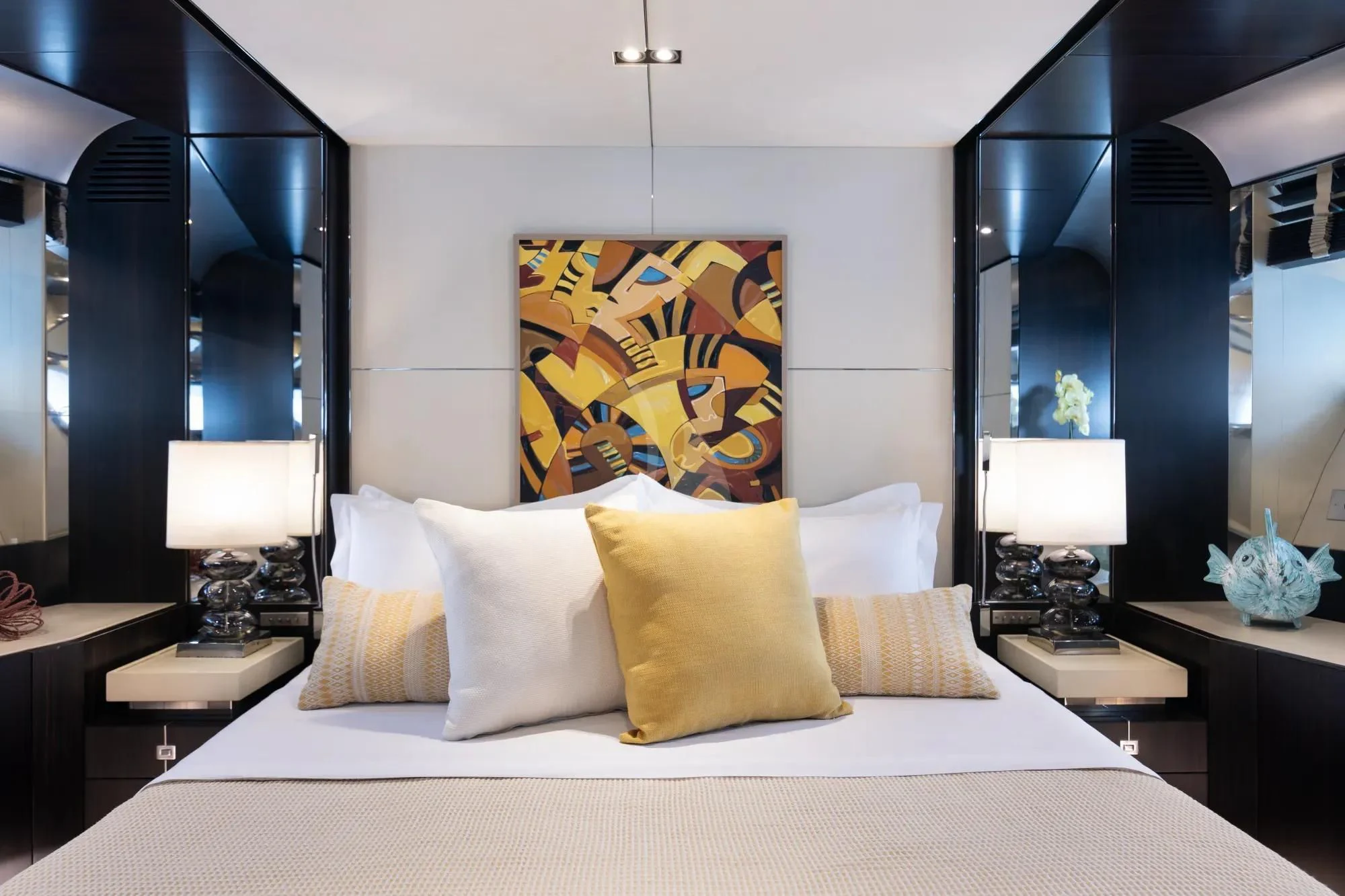 a bed with pillows and a painting on the wall aboard MAC Yacht for Sale