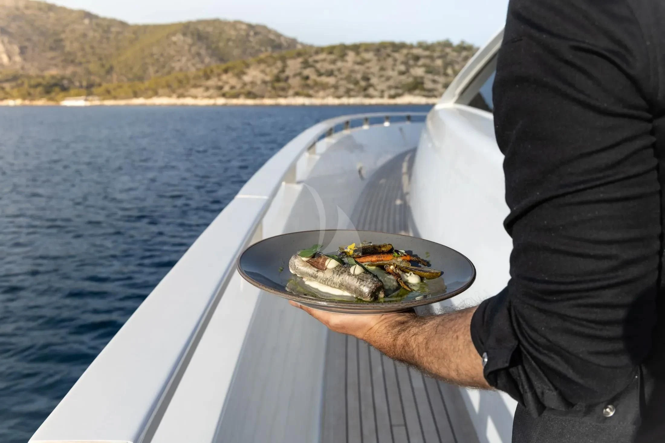 a person holding a sandwich on a boat aboard MAC Yacht for Sale