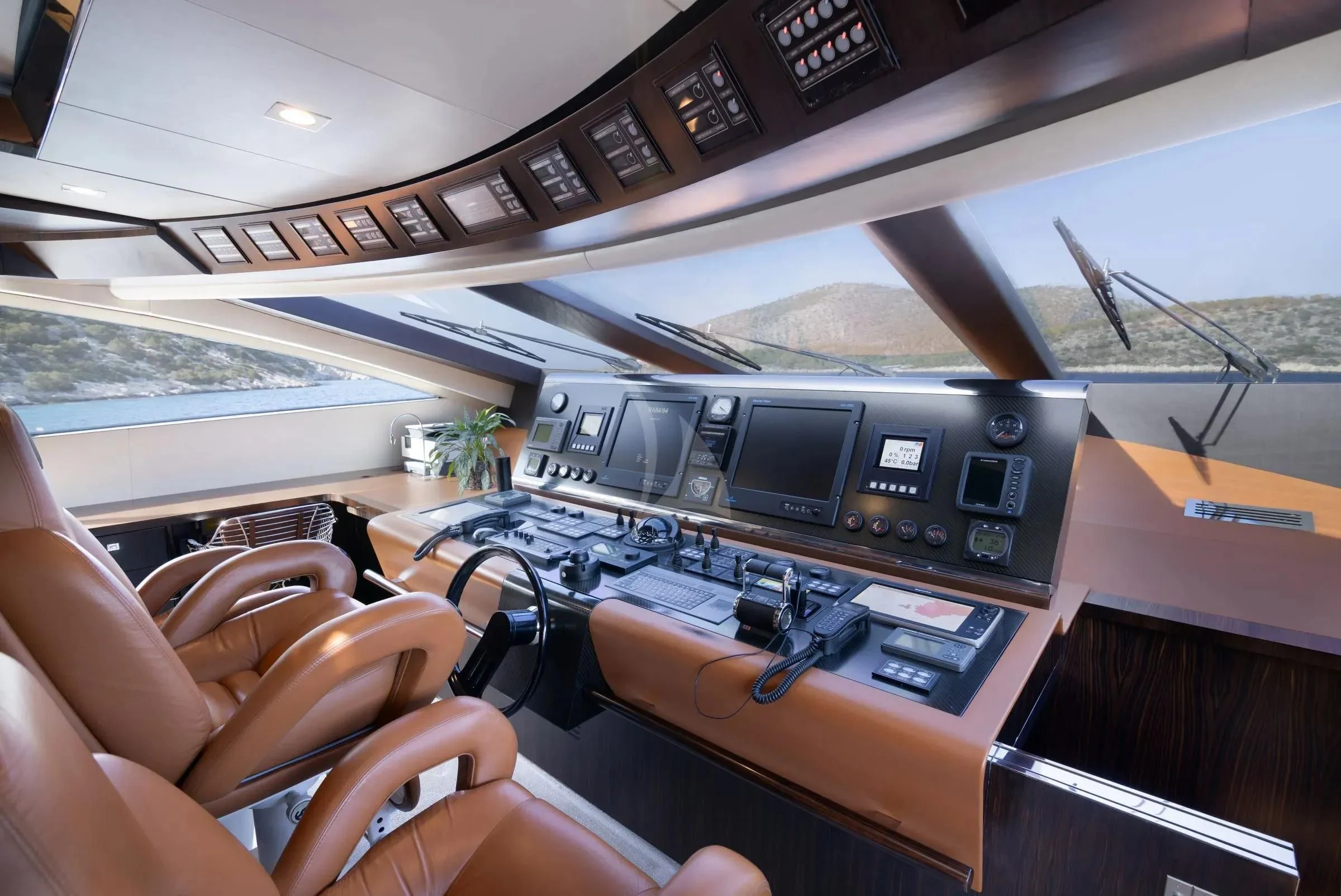 a person's hands holding a device in a cockpit aboard MAC Yacht for Sale